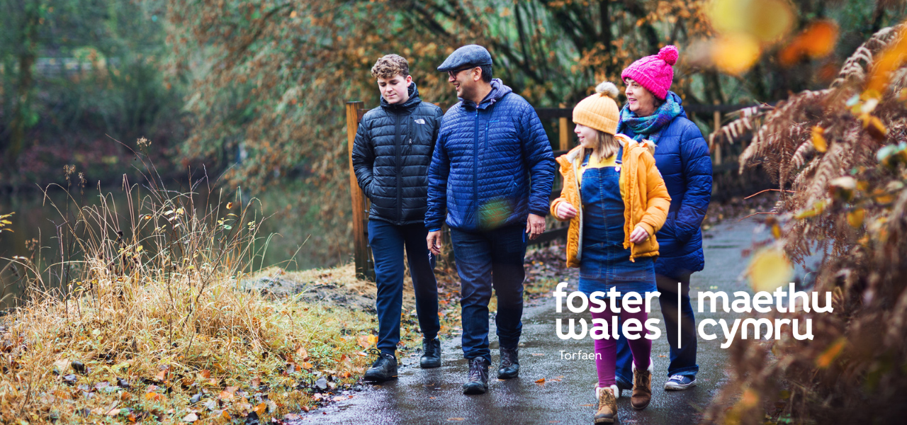 Foster wales hero image of family walking near a lake
