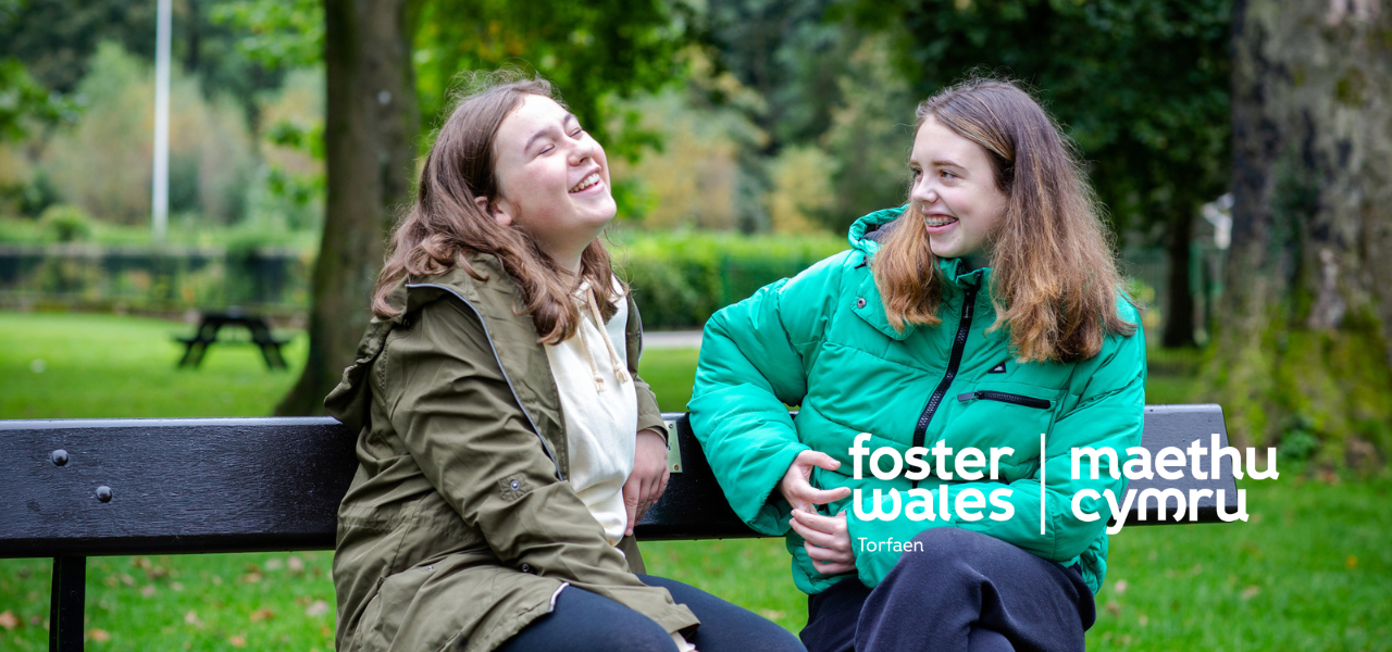 foster wales hero image of two girls laughing on park bench