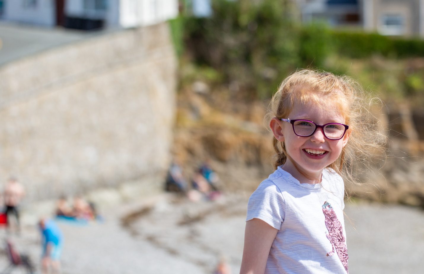 A girl wearing glasses and smiling to the camera