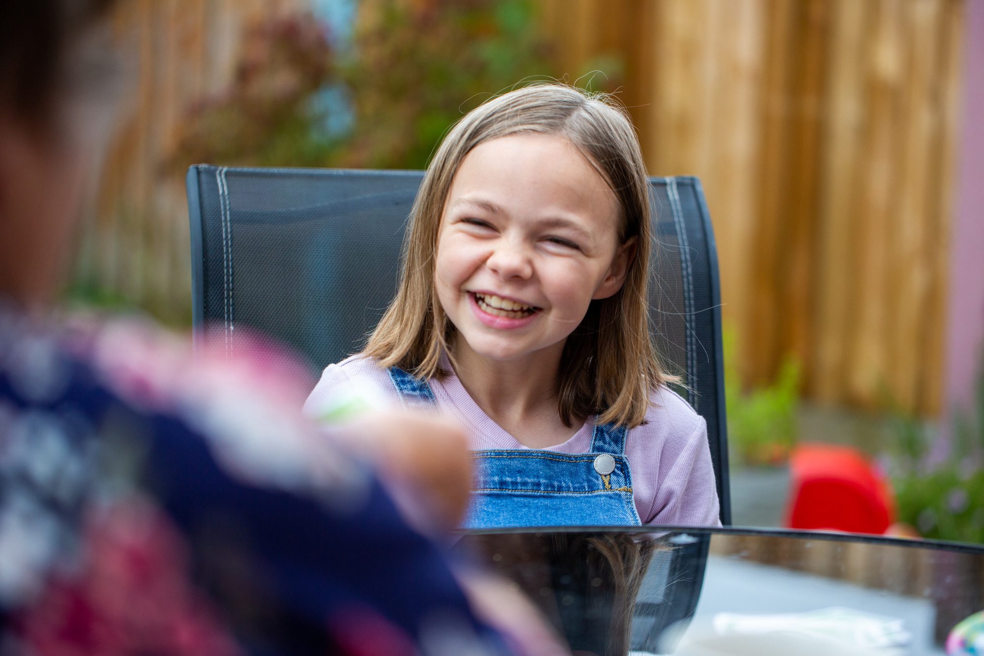 young girl laughing at a garden table