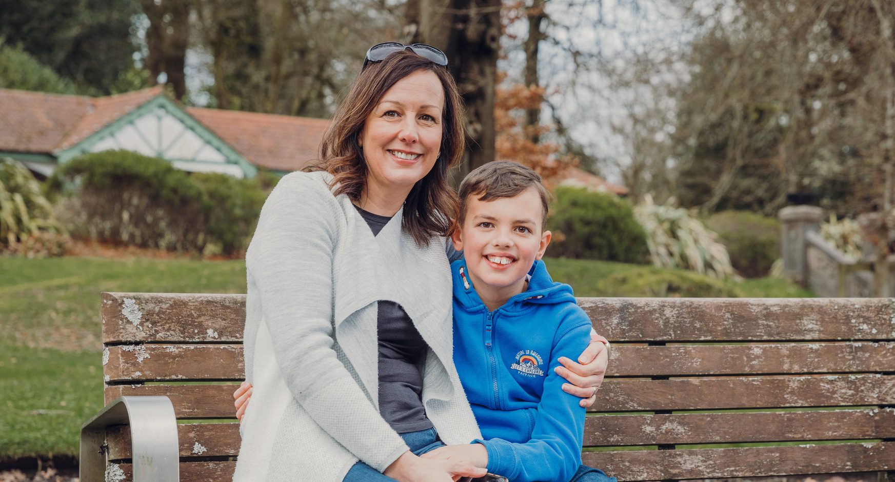 A woman and a boy sitting on a bench